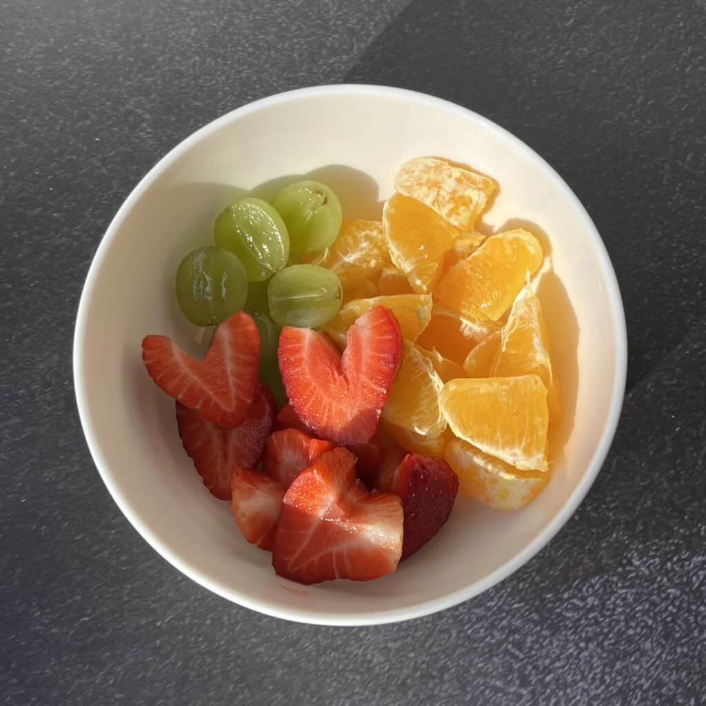 Bowl of fruit including grapes, strawberries, orange